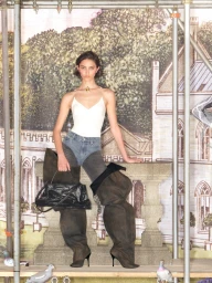 Model in white top, denim-waisted trousers, and oversized boots holding a black handbag against an illustrated estate backdrop