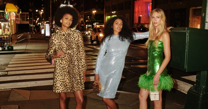 Three models posing on a city street at night wearing designer dresses for Saks Fifth Avenue photographed by Angelo Pennetta.