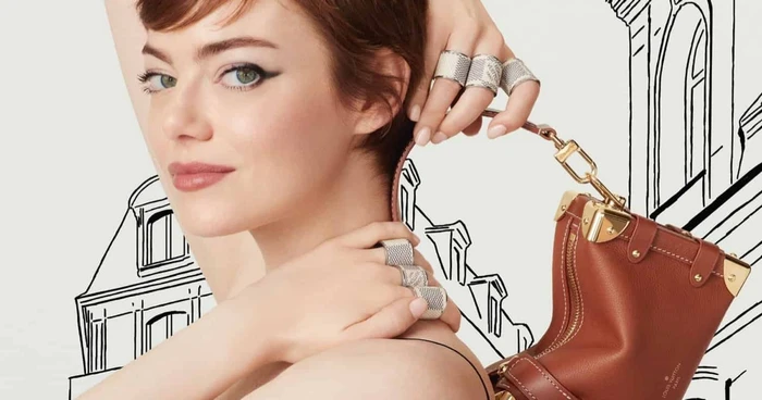 Emma Stone with short auburn hair wearing patterned rings and holding a brown leather handbag against an illustrated backdrop.