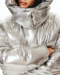 Kylie Jenner wearing a shiny metallic silver puffer jacket with an oversized collar for Khy Fall 2025.