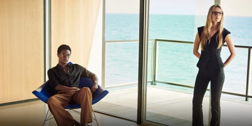 Two models wearing eyewear inside a modern room with ocean views for Oliver Peoples Malibu Forever