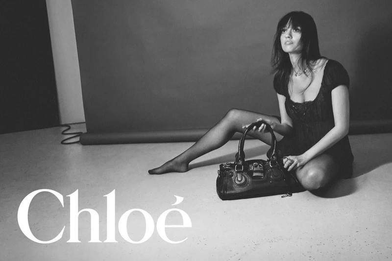 Model seated on a studio floor with a black leather handbag for Chloe winter 2025 campaign