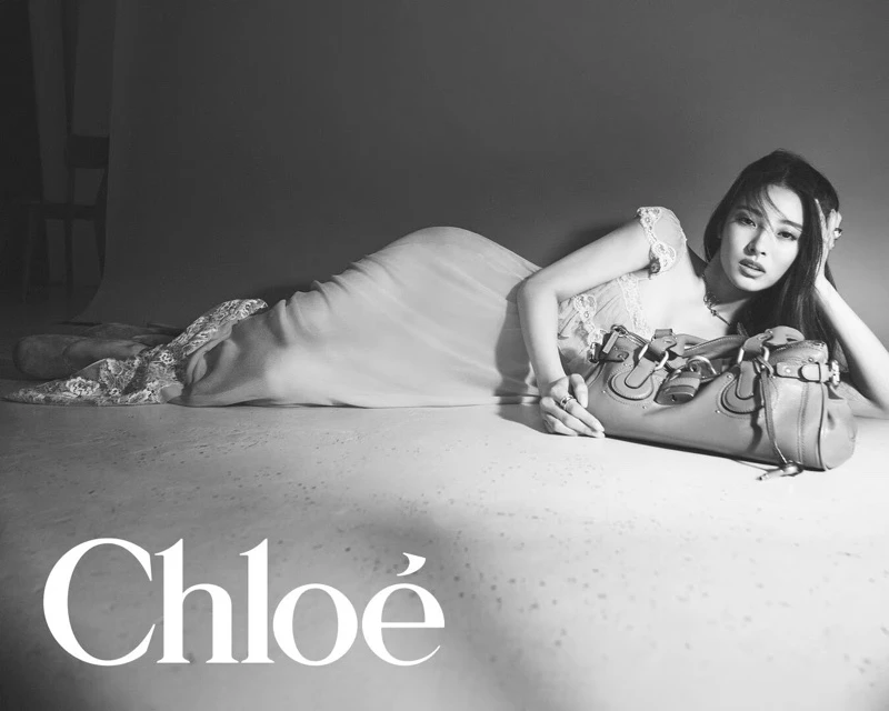 Model lying on the floor with a leather handbag in a monochrome fashion campaign for Chloé