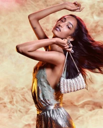 Mona Tougaard wearing a metallic dress and holding a chainmail handbag for Rabanne Fall-Winter 2025 Campaign
