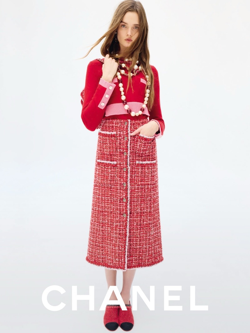 Model Lulu Tenney in red tweed skirt and matching top with pearl necklaces against a white seamless background for Chanel Fall-Winter.