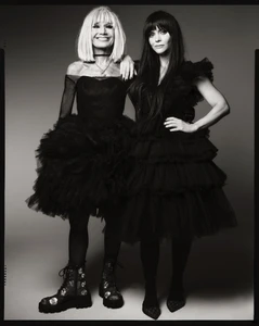 Betsey Johnson and Christina Ricci wearing black tulle dresses against a grey studio backdrop for Fall 2025 campaign.