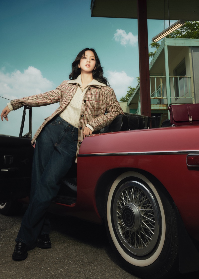Jisoo poses leaning against a vintage red convertible wearing a plaid jacket, cream knit, and dark denim jeans.