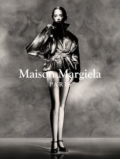 Miley Cyrus in a Maison Margiela campaign wearing a glossy jacket and holding a bag against a textured backdrop