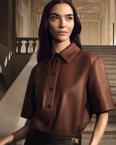 Model in brown leather button-up shirt standing on grand stone staircase for Salvatore Ferragamo campaign