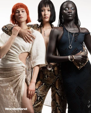 Three female models posing together for Wonderland Magazine, wearing textured designer fashion against a plain white background.