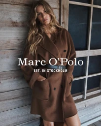 Gisele Bundchen wearing a brown coat and black belt leaning against a rustic wooden wall for Marc O Polo Fall-Winter 2025 Campaign