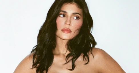 Kylie Jenner with dark wavy hair posing against a clean white backdrop for the Khy Cotton Stretch campaign.