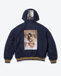 Back view of a navy blue hooded varsity jacket with photographic print patches against a clean white backdrop.