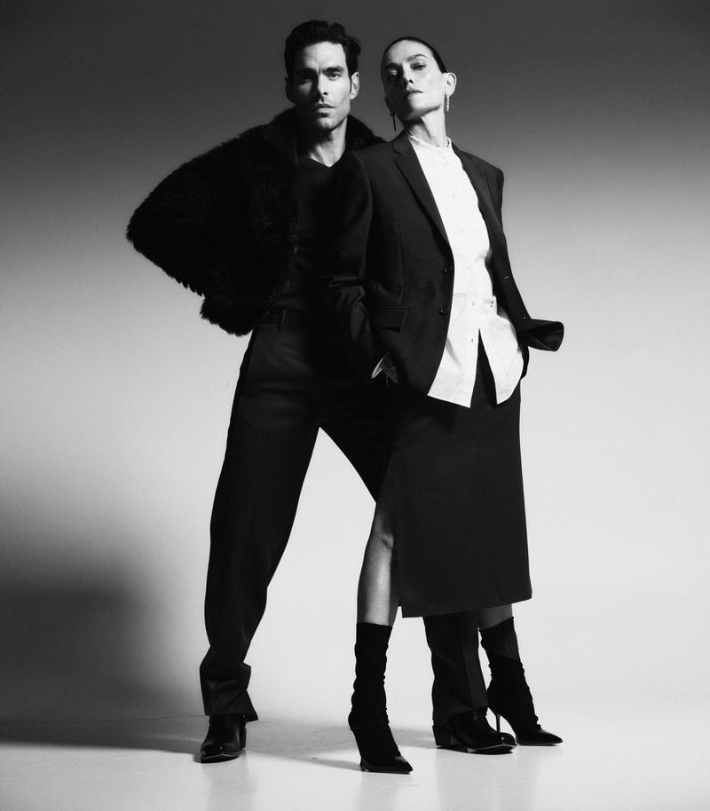Jon Kortajarena and Laura Ponte posing in tailored black and white attire against a studio backdrop.