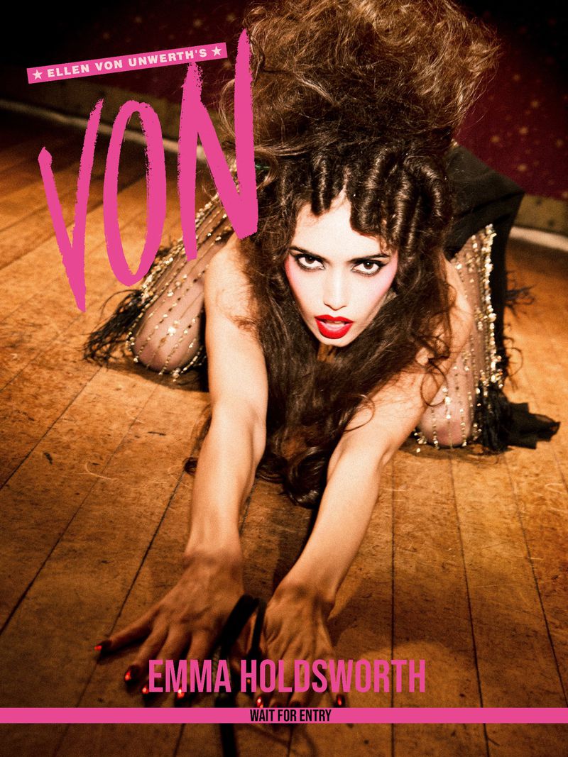 Model Emma Holdsworth crawling forward on a rustic wooden floor with voluminous styled hair for VON Magazine cover.