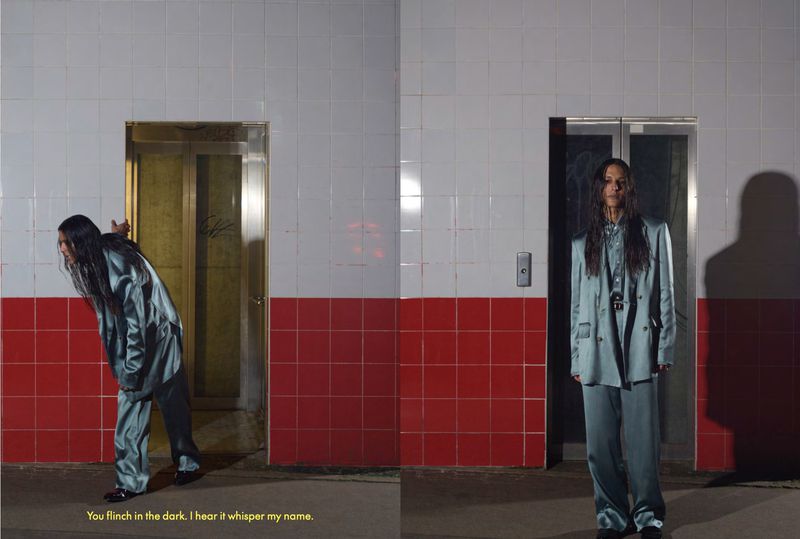 Person wearing a blue suit standing near an elevator, with a white and red tiled wall in the background, and the same person looking into an elevator.
