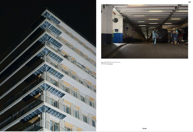 Exterior corner of a modern high-rise apartment building at night with balconies and windows, plus a pedestrian underpass with person walking.