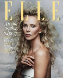 Charlize Theron with voluminous blonde curls and a white strapless garment on the Elle UK cover with a cloudy backdrop.
