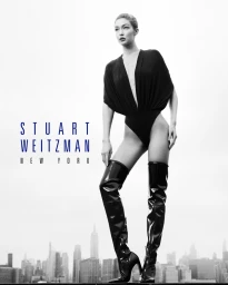 Gigi Hadid standing on a rooftop in a black bodysuit and over-the-knee boots for Stuart Weitzman Fall 2026 campaign.