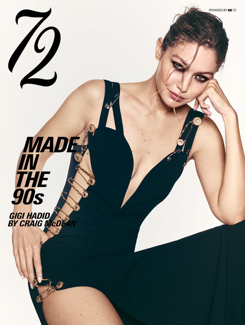 Model Gigi Hadid posing in a black safety pin gown against a white studio background for 72 Magazine.