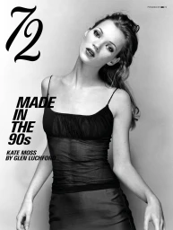Black and white portrait of Kate Moss in a black sheer spaghetti-strap camisole top against a grey studio backdrop.