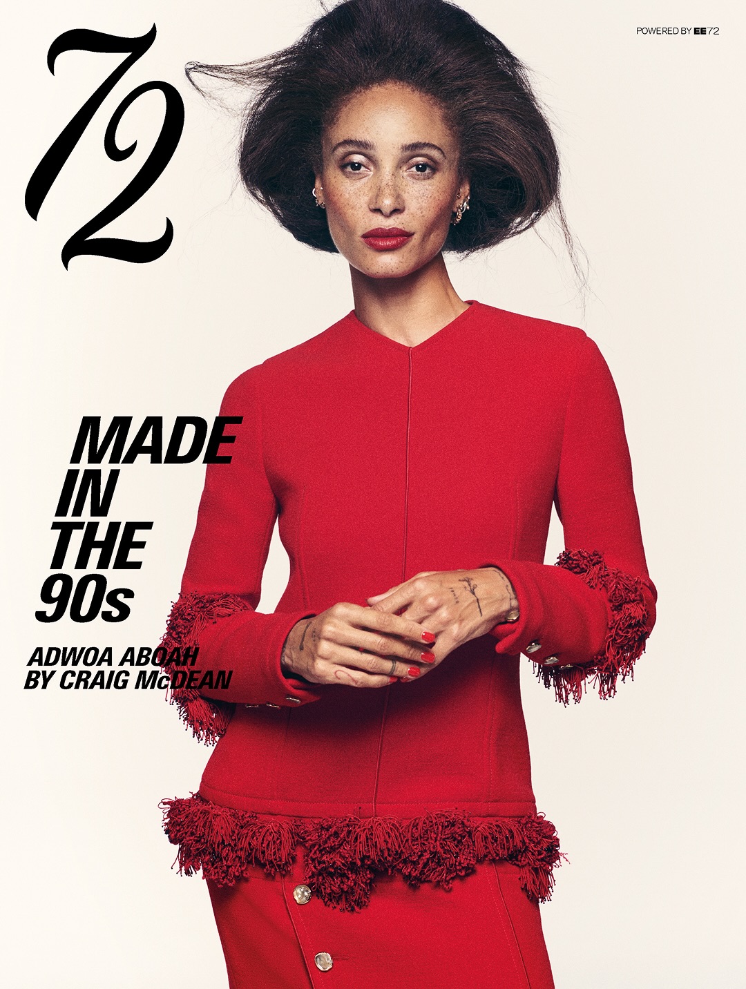 Model Adwoa Aboah wearing a red textured-trim suit with retro bouffant hair against an off-white background for 72 Magazine.