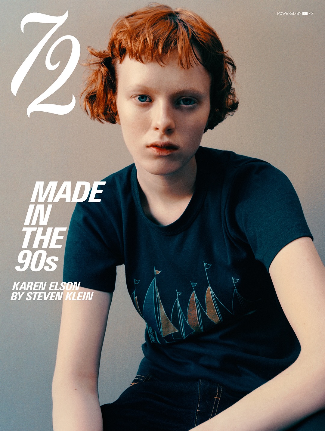 Model Karen Elson with short red hair wearing a dark graphic t-shirt against a neutral studio backdrop on a magazine cover.