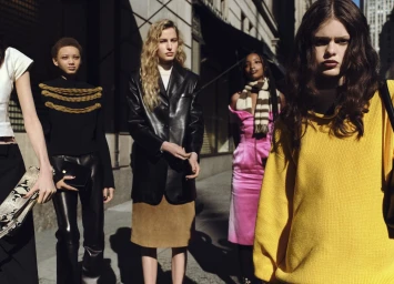 Models standing together on a sunlit city sidewalk wearing vibrant knitwear and tailored outerwear for Saks Fifth Avenue.