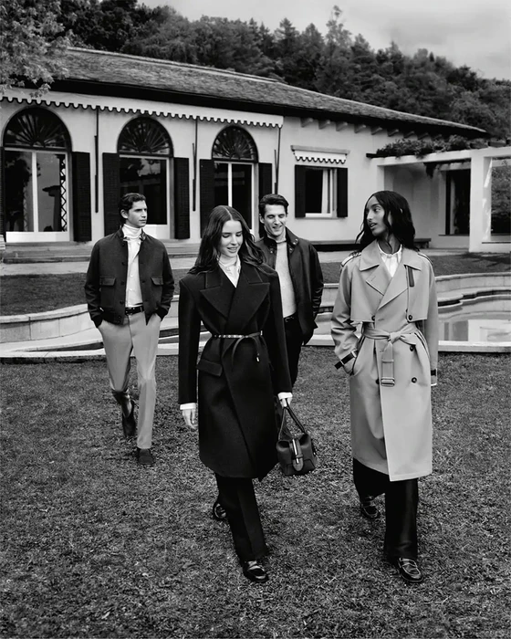 Four models walking on a lawn in front of a classical building for Tods Italian Stories campaign, photographed in black and white by Alasdair McLellan.
