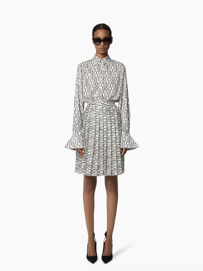 A full-length shot showcases a Black female model in a patterned blouse and pleated skirt, accessorized with sunglasses and high heels.