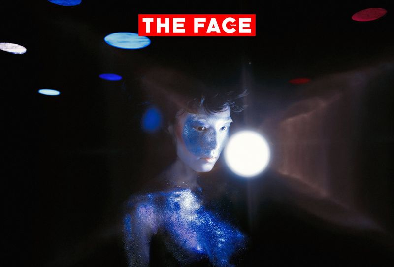 Model with blue face and body glitter posing next to a bright light sphere against a dark background for The Face China.