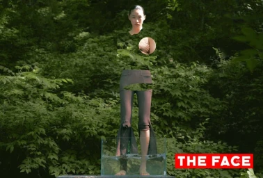 East Asian model with camouflaged torso standing barefoot in a clear glass water tank against dense green forest foliage.