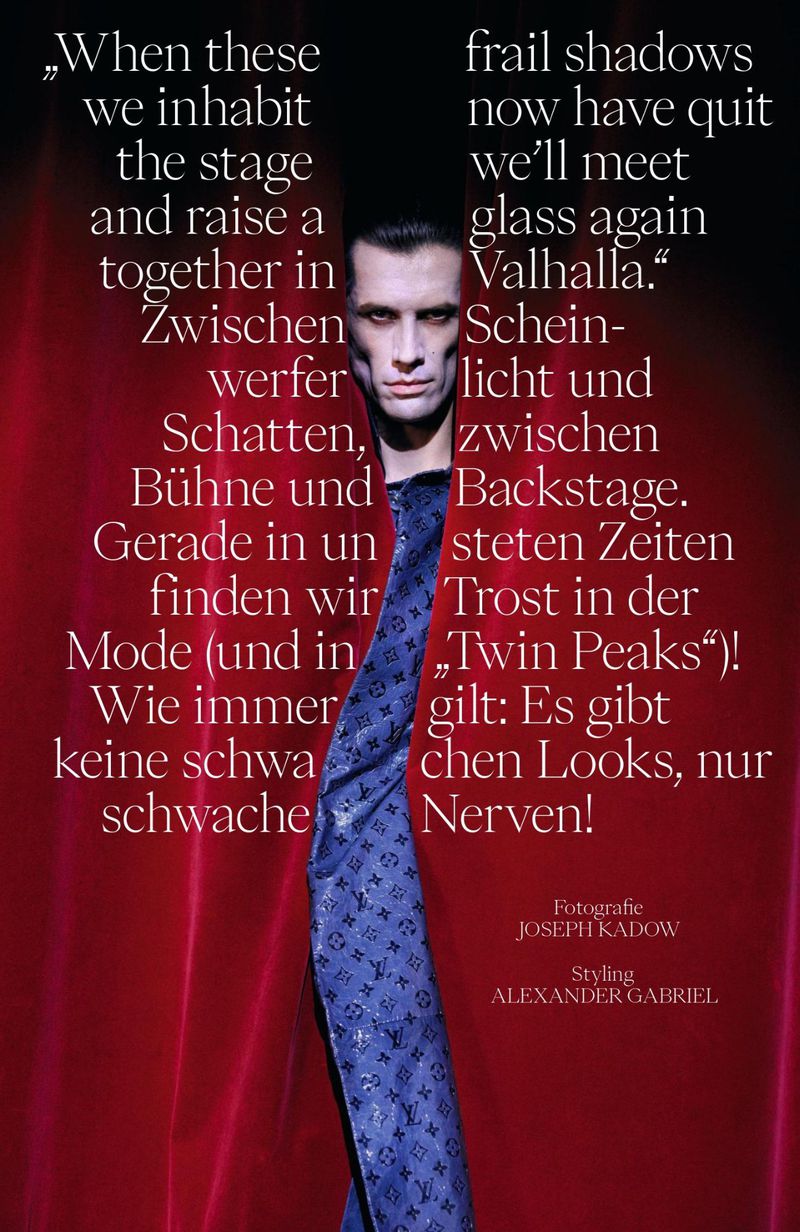 Model Kamil Skłodowski framed between deep red velvet curtains wearing a blue patterned jacket with typography overlay.