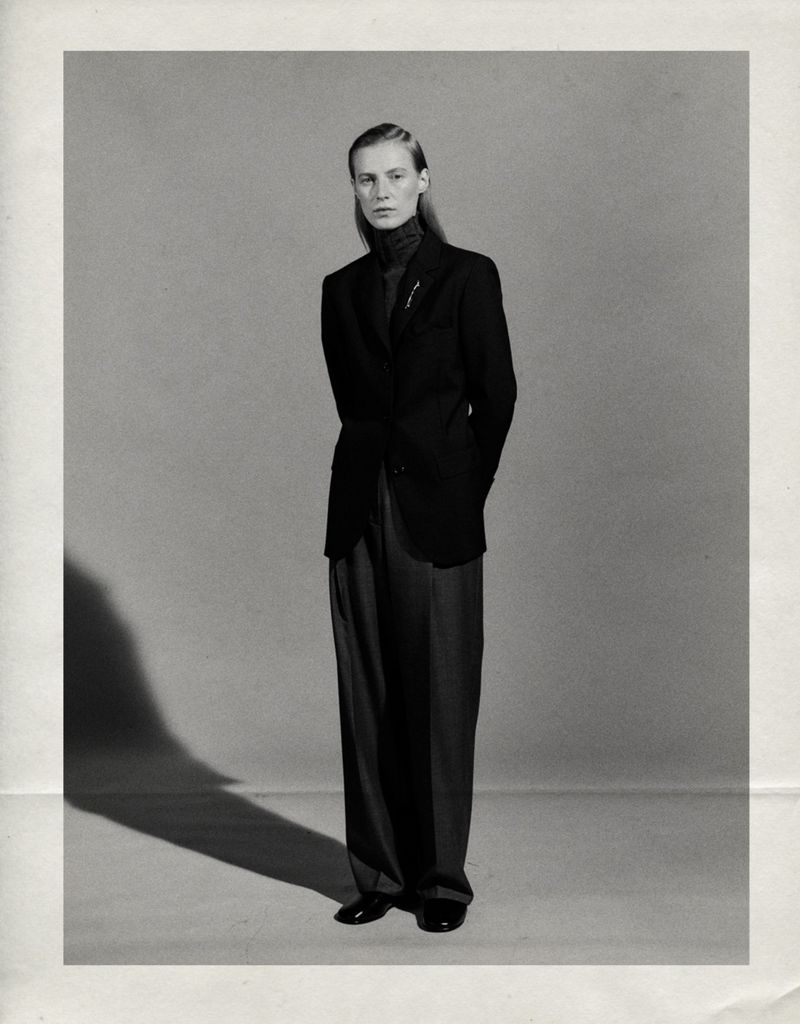 Julia Nobis standing in a black tailored blazer and wide-leg trousers against a neutral studio backdrop for Massimo Dutti.