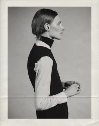 Model Julia Nobis in side profile wearing a black vest over a white collared shirt for Massimo Dutti.