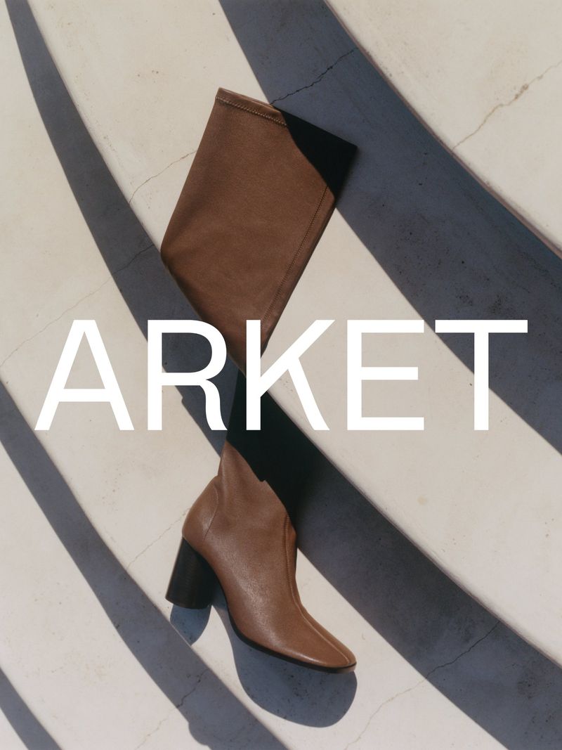 Brown leather high-heeled boot placed on a diagonally striped concrete surface with white Arket branding overlay.