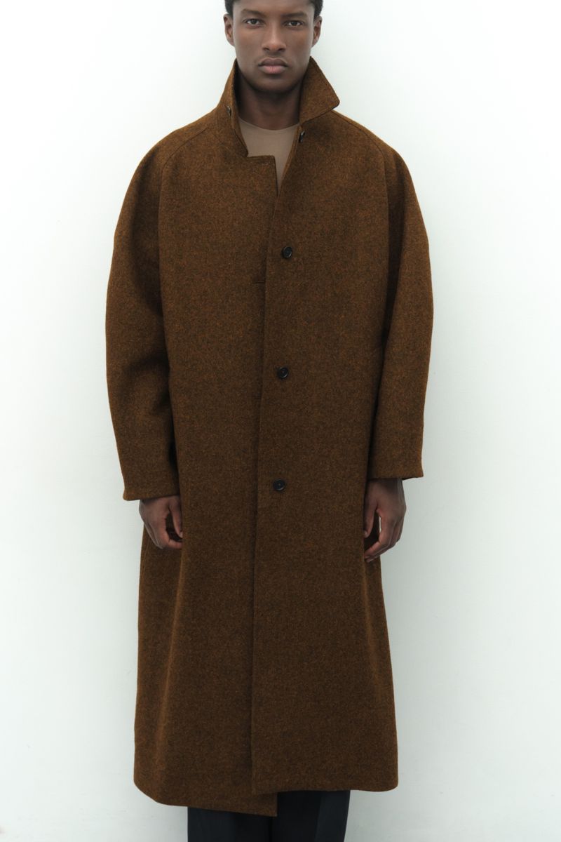 Model Aboubakar Konte wearing an oversized textured brown wool coat against a plain white background.