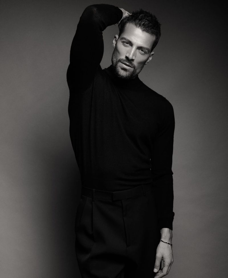 Monochrome portrait of model Simone Susinna wearing a black turtleneck and black trousers against a neutral studio backdrop.