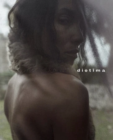 Close-up portrait of model Romae Gordon looking over a bare shoulder with textured grain for the Diotima campaign.