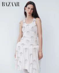 Model Ruby Aldridge wearing a white dress adorned with small bows against a white seamless background for Harper's Bazaar Thailand