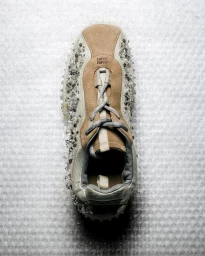Top-down view of a crystal-embellished Miu Miu suede sneaker resting on clear textured bubble wrap.