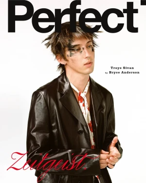 Troye Sivan wearing a black leather jacket with smudged eye makeup on the cover of The Perfect Magazine.