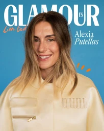 Alexia Putellas smiling on the cover of Glamour Spain magazine against a bright blue background wearing a cream jacket