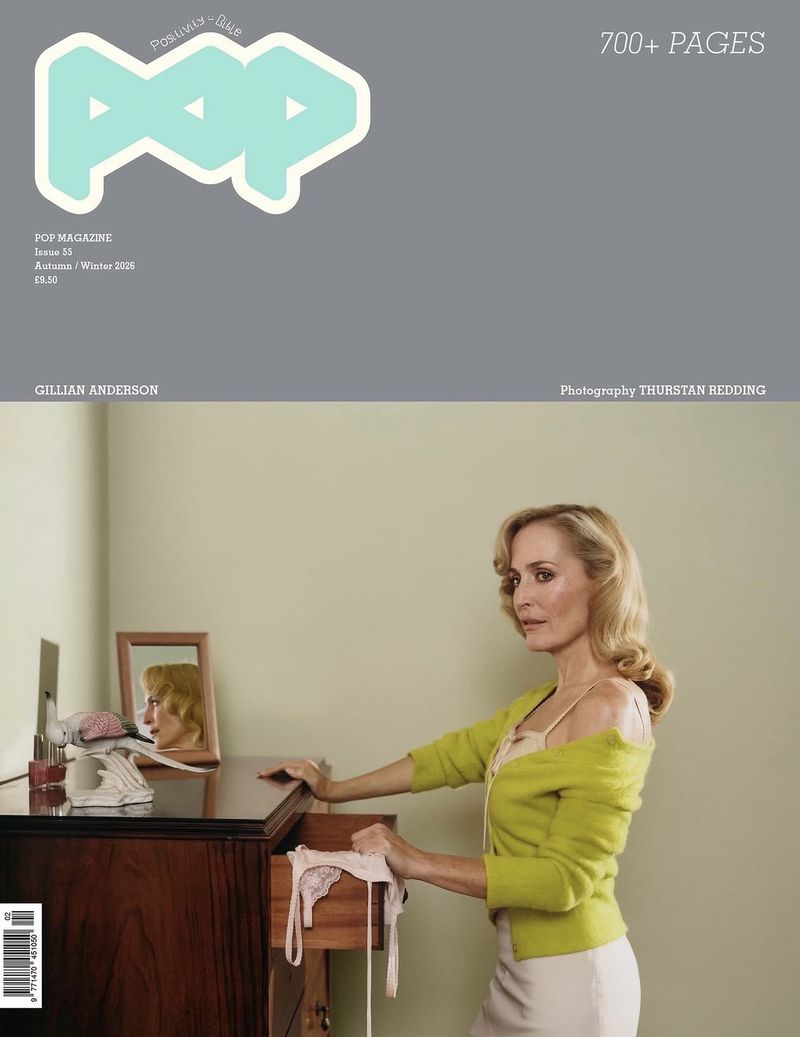 Gillian Anderson posing beside a wooden dresser with an open drawer on the cover of Pop Magazine.