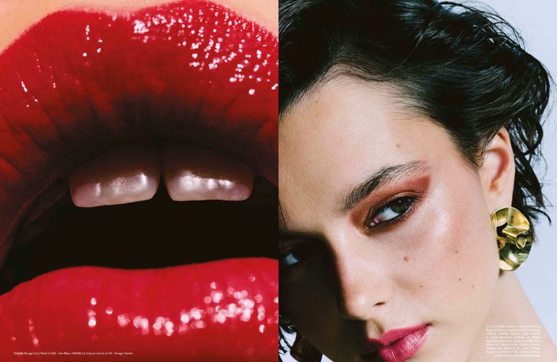 Close-up beauty shot features adult woman with red lipstick, artful eye makeup and bold gold earrings. Bright studio lighting, fashion editorial.