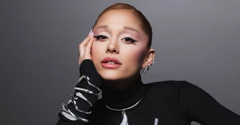 Ariana Grande wearing silver crystal jewellery and black turtleneck against grey background for Swarovski
