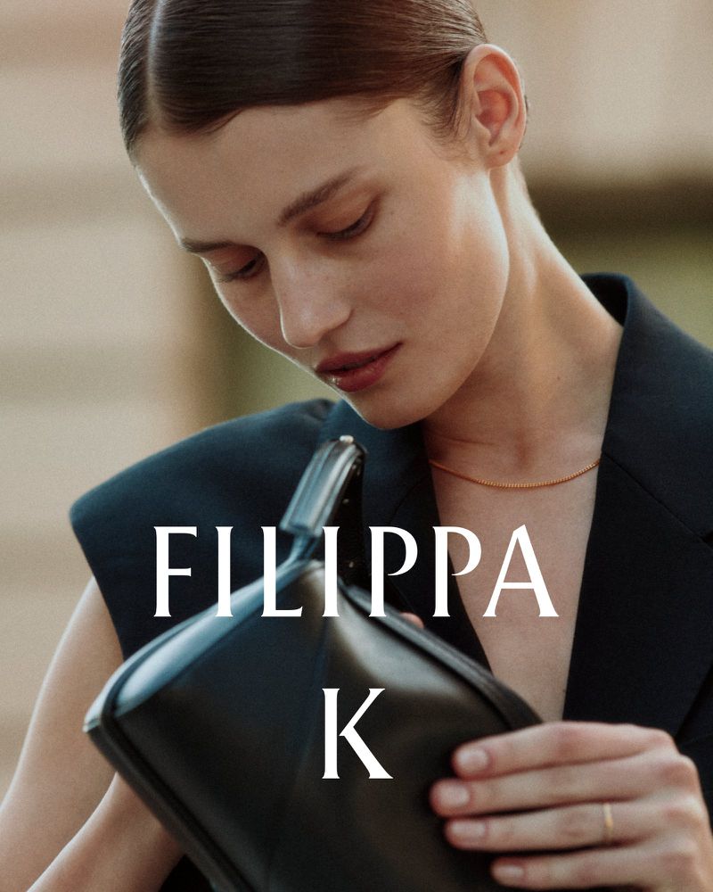 Model Lesia Havrylets holding a black leather handbag wearing a black blazer for the Filippa K AW26 Pre Campaign.