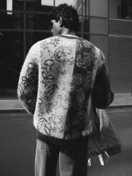 Model Earl Cordeiro seen from behind wearing a floral patterned knit sweater outdoors for Topman SS26.