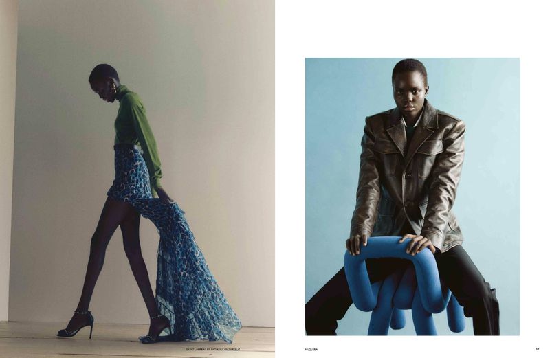 Editorial fashion shot: a slender model in green top and flowing blue skirt strides by a seated model in a leather jacket.