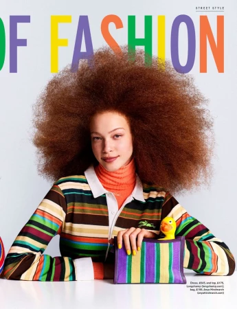Model Tianna St. Louis with voluminous auburn afro hair posing with a striped clutch bag and yellow rubber duck against a white backdrop.